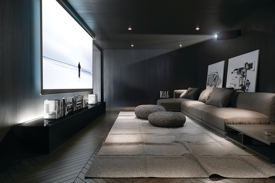A luxury home theater with fancy gray seats and a Sony projector displaying a landscape.